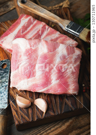 Raw pork ribs with spices, salt and rosemary on dark wooden background 130711965