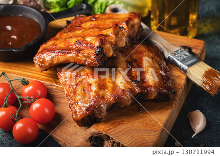 Spicy hot grilled spare ribs from a summer BBQ served with a hot chili pepper and fresh tomatoes Spicy hot grilled spare ribs from a summer BBQ served with a hot chili pepper and fresh tomatoes 130711994