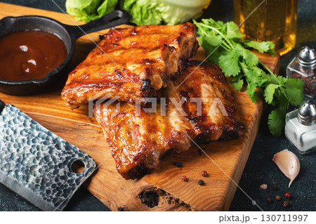Spicy hot grilled spare ribs from a summer BBQ served with a hot chili pepper and fresh tomatoes 130711997