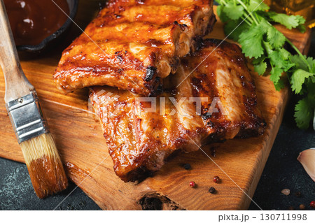 Spicy hot grilled spare ribs from a summer BBQ served with a hot chili pepper and fresh tomatoes Spicy hot grilled spare ribs from a summer BBQ served with a hot chili pepper and fresh tomatoes 130711998