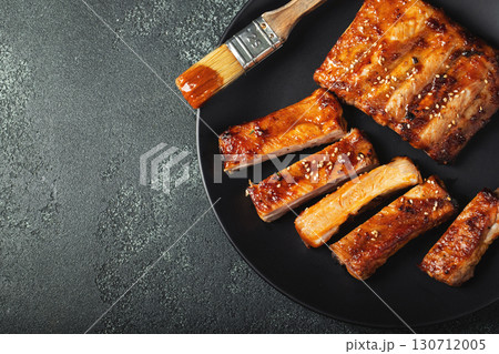 Hot grilled spare ribs from a summer BBQ served on a plate with sauce. Top view. Copy space 130712005