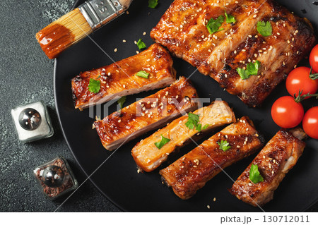 Hot grilled spare ribs from a summer BBQ served on a plate with sauce. Top view. Copy space Hot grilled spare ribs from a summer BBQ served on a plate with sauce. Top view. Copy space 130712011