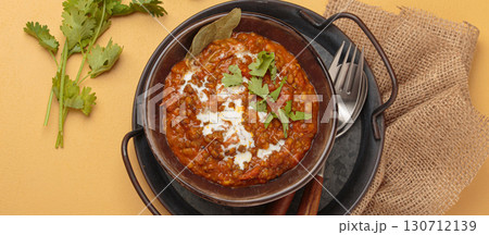 Dal makhani with cream and coriander in bowl is served with spices top view, traditional dish of India 130712139