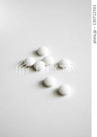 White round tablets scattered on clean background, pharmaceutical medicine for treatment, healthcare and medical therapy White round tablets scattered on clean background, pharmaceutical medicine for treatment, healthcare and medical therapy 130712501