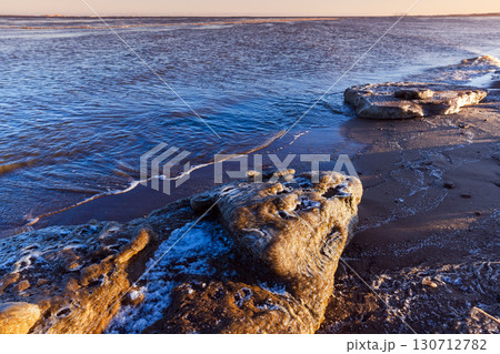 Exquisite ice fragments located by the shoreline, surrounded by soft sea waves 130712782