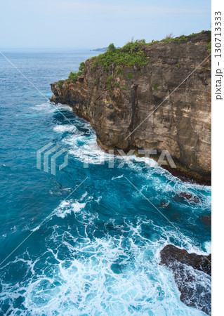 Cinematic aerial landscape shots of the beautiful island of Nusa Penida. Huge cliffs by the shoreline and hidden dream beaches with clear water and foaming wave. Cinematic aerial landscape shots of the beautiful island of Nusa Penida. Huge cliffs by the shoreline and hidden dream beaches with clear water and foaming wave. 130713333
