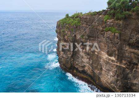 Cinematic aerial landscape shots of the beautiful island of Nusa Penida. Huge cliffs by the shoreline and hidden dream beaches with clear water and foaming wave. Cinematic aerial landscape shots of the beautiful island of Nusa Penida. Huge cliffs by the shoreline and hidden dream beaches with clear water and foaming wave. 130713334