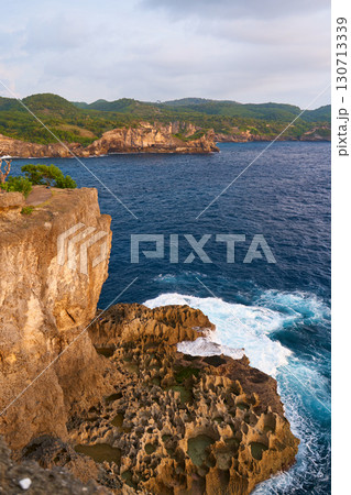 Cinematic aerial landscape shots of the beautiful island of Nusa Penida. Huge cliffs by the shoreline and hidden dream beaches with clear water and foaming wave. Cinematic aerial landscape shots of the beautiful island of Nusa Penida. Huge cliffs by the shoreline and hidden dream beaches with clear water and foaming wave. 130713339