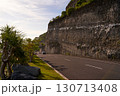 The cliff overhangs along the road to the ocean at sunset. 130713408