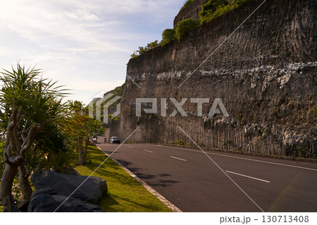 The cliff overhangs along the road to the ocean at sunset. The cliff overhangs along the road to the ocean at sunset. 130713408