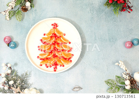 Edible Christmas tree made of tangerines and pomegranate for a festive table, an idea for decorating food and decorating New Year dishes for children. Banner and template for creativity, 130713561