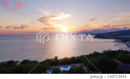 Sunset over the sea coast, golden reflection on water and panoramic horizon 130713841