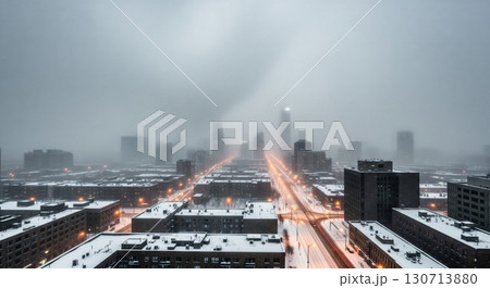 Snowy Cityscape With Tall Buildings and Streetlights During Winter Storm Aerial View 130713880