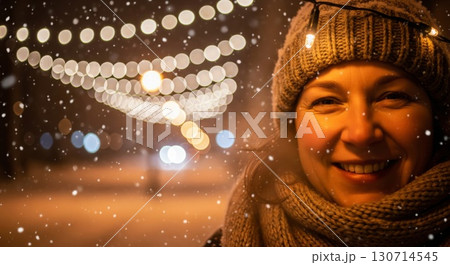 Smiling Woman with Gray Knit Hat and Scarf During Snowfall at Night 130714545
