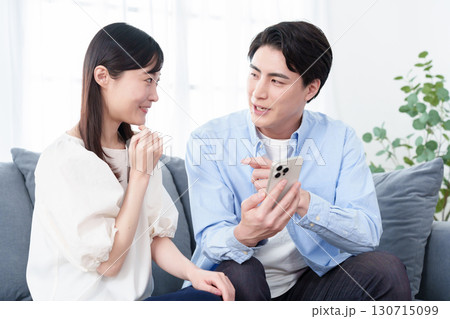 スマートフォンを使う若い男女 スマートフォンを使う若い男女 130715099