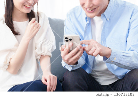 スマートフォンを使う若い男女の手元 スマートフォンを使う若い男女の手元 130715105