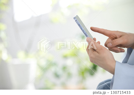 スマホを操作するミドル女性の手元 スマホを操作するミドル女性の手元 130715433