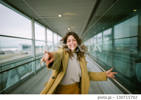 A woman in a yellow coat is smiling and pointing to the sky A woman in a yellow coat is smiling and pointing to the sky 130715702
