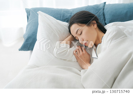 ベッドで眠る若い女性 130715740