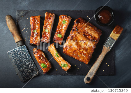 Barbecue pork spare ribs with hot honey chili marinade on black background Barbecue pork spare ribs with hot honey chili marinade on black background 130715849
