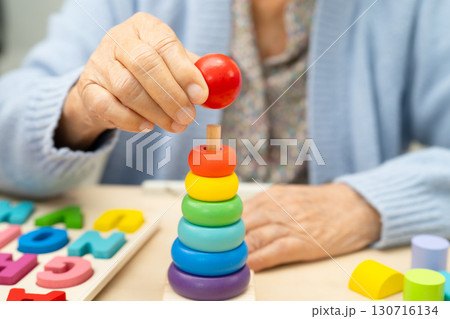 Alzheimer disease AD, Asian elderly woman patient suffering from dementia learn practical motor skills rehabilitation. Alzheimer disease AD, Asian elderly woman patient suffering from dementia learn practical motor skills rehabilitation. 130716134