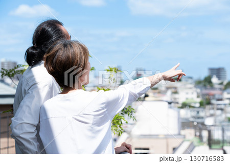 テラスで街を眺めるシニア夫婦 テラスで街を眺めるシニア夫婦 130716583