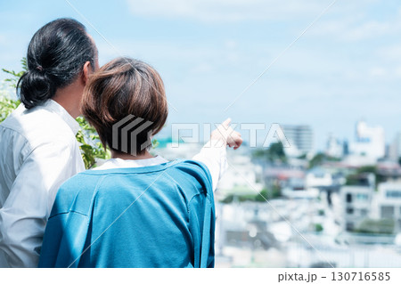 テラスで街を眺めるシニア夫婦 テラスで街を眺めるシニア夫婦 130716585