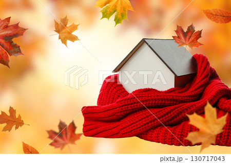 A house wrapped in a red scarf surrounded by autumn leaves 130717043