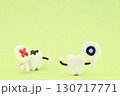 マル印をもったミニチュアの歯と後ろにいるバツ印をもったミニチュアの虫歯 130717771