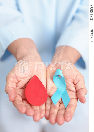 Elderly woman with Blue ribbon and red Blood drop for World Diabetes Day, Blue November Health, Prostate Cancer awareness, Blood sugar check, Insulin, Glucose screening, donation and Health checkup 130718652