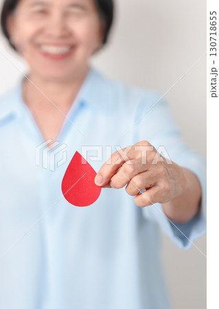 Elderly woman in blue shirt with red Blood drop for World Diabetes Day, Blue November Health month, Diabetes awareness, Blood sugar check, Insulin, Glucose screening, blood donoo and Health checkup 130718655