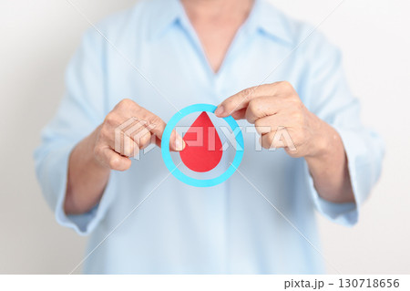 Elderly woman with Blue Circle and red Blood drop for World Diabetes Day, Blue November Health month, Diabetes awareness, Blood sugar check, Insulin, Glucose screening, donation and Health checkup 130718656