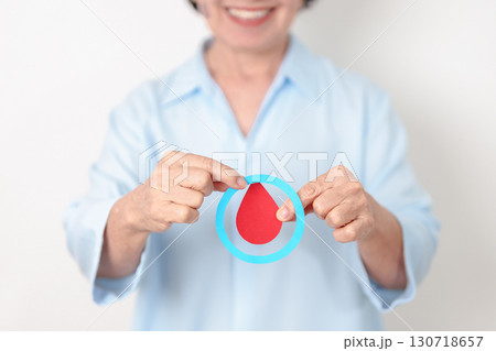 Elderly woman with Blue Circle and red Blood drop for World Diabetes Day, Blue November Health month, Diabetes awareness, Blood sugar check, Insulin, Glucose screening, donation and Health checkup 130718657