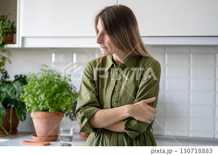 Anxious woman biting lips, lost in thoughts at home. Burnout female in tension and emotional fatigue 130718883
