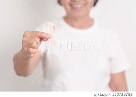 Elderly woman with Peach Ribbon for September Uterine Cancer Awareness month, Endometrial Cancer, Gynecologic, Uterus and Ovaries, Endometriosis, June Vaginal cancer and World cancer day concept 130720782