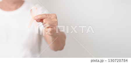 Elderly woman with Peach Ribbon for September Uterine Cancer Awareness month, Endometrial Cancer, Gynecologic, Uterus and Ovaries, Endometriosis, June Vaginal cancer and World cancer day concept 130720784
