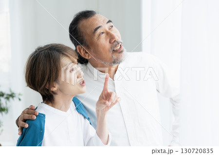 窓際で外を見るシニア夫婦 130720835