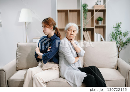 Mother and Daughter in Serious Disagreement emotional tension in silence on sofa at home, stressed after quarrel, ignoring each other 130722136