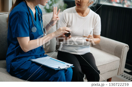 Asian caregiver doctor examine older patient woman therapist nurse at nursing home taking care of senior elderly woman sit on sofa.Medical service concept. Asian caregiver doctor examine older patient woman therapist nurse at nursing home taking care of senior elderly woman sit on sofa.Medical service concept. 130722259