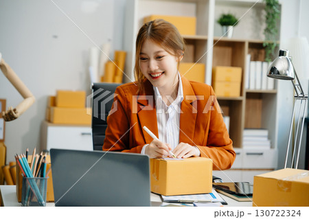 Young woman running online store Startup small business SME, using smartphone or tablet taking receive and checking Young woman running online store Startup small business SME, using smartphone or tablet taking receive and checking 130722324