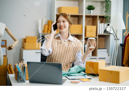 Young  woman prepare parcel box and standing check online orders for deliver to customer on tablet, laptop Shopping Online concept. 130722327