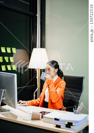 Young beautiful woman typing on tablet and laptop while sitting at the working Young beautiful woman typing on tablet and laptop while sitting at the working 130722519