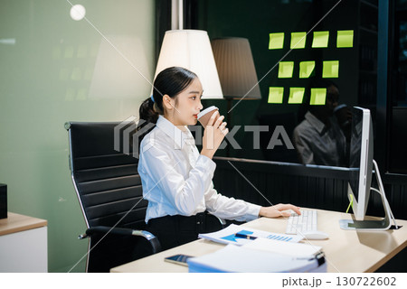 Young beautiful woman typing on tablet and laptop while sitting at the working Young beautiful woman typing on tablet and laptop while sitting at the working 130722602