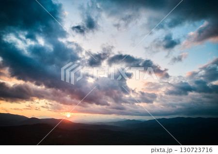 Aerial view breathtaking sunset over forest. Sun's rays break through dramatic clouds. Aerial view breathtaking sunset over forest. Sun's rays break through dramatic clouds. 130723716