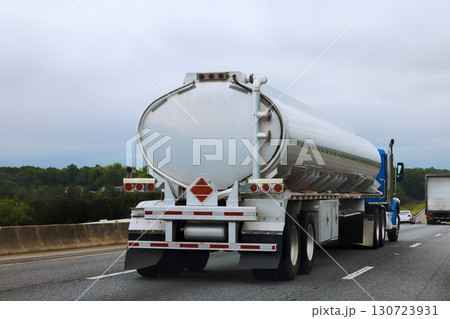 Tank truck driving travels along American highway under overcast skies its sleek design. 130723931