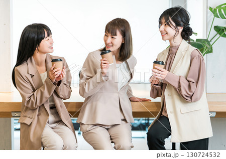 会社,オフィスでコーヒを飲みながら談笑するビジネスマンとビジネスウーマン 130724532