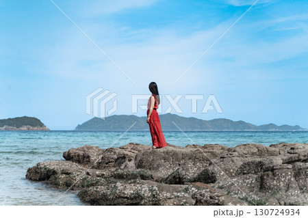 海辺に立つ赤いワンピースの女性② 130724934