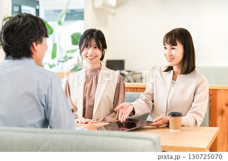 商談スペースのテーブルで商談,打ち合わせをするビジネスマンとビジネスウーマン 130725070