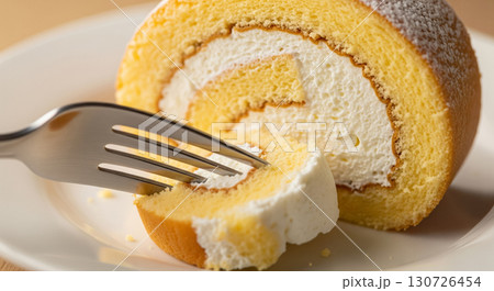 Fork Cutting into Cream Filled Swiss Roll 130726454