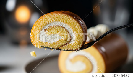 Fork Holding Slice of Vanilla Swiss Roll with Caramel Glaze 130726487